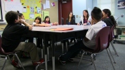Monica Karafin (in white jacket), a San Diego State University graduate student, meets with the Pathfinders, a group of fourth and fifth graders who are learning to become peer mediators. Today, they'll do an exercise that helps them use words when it would be easier to show how to draw an image. Then they'll visit the playground, where they will eventually help mediate conflicts.
