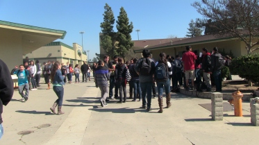 Students gather to watch two girls get in a fight. They were marched to the principal's office and then escorted off campus. 