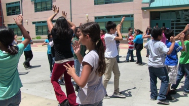 Fifth-grade students practice a dance in courtyard of Harmony Elementary School in Los Angeles, CA.