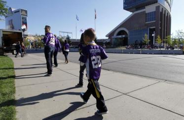 A young fan wears an Adrian Peterson jersey.  [Photo: Ann Heisenfelt/AP]