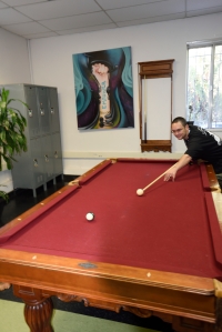 SDYS staff member Justin Floyd playing pool while on break at the TAY Academy. 